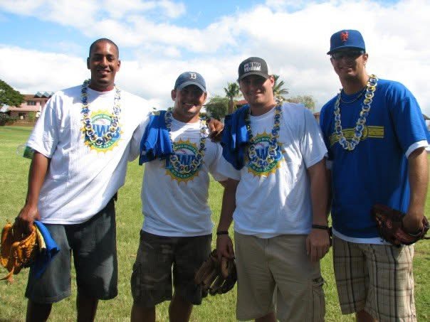 Harold Williams, Michael McKenry, Daniel Murphy and Brant Rustich wearing leis on a field in Hawaii